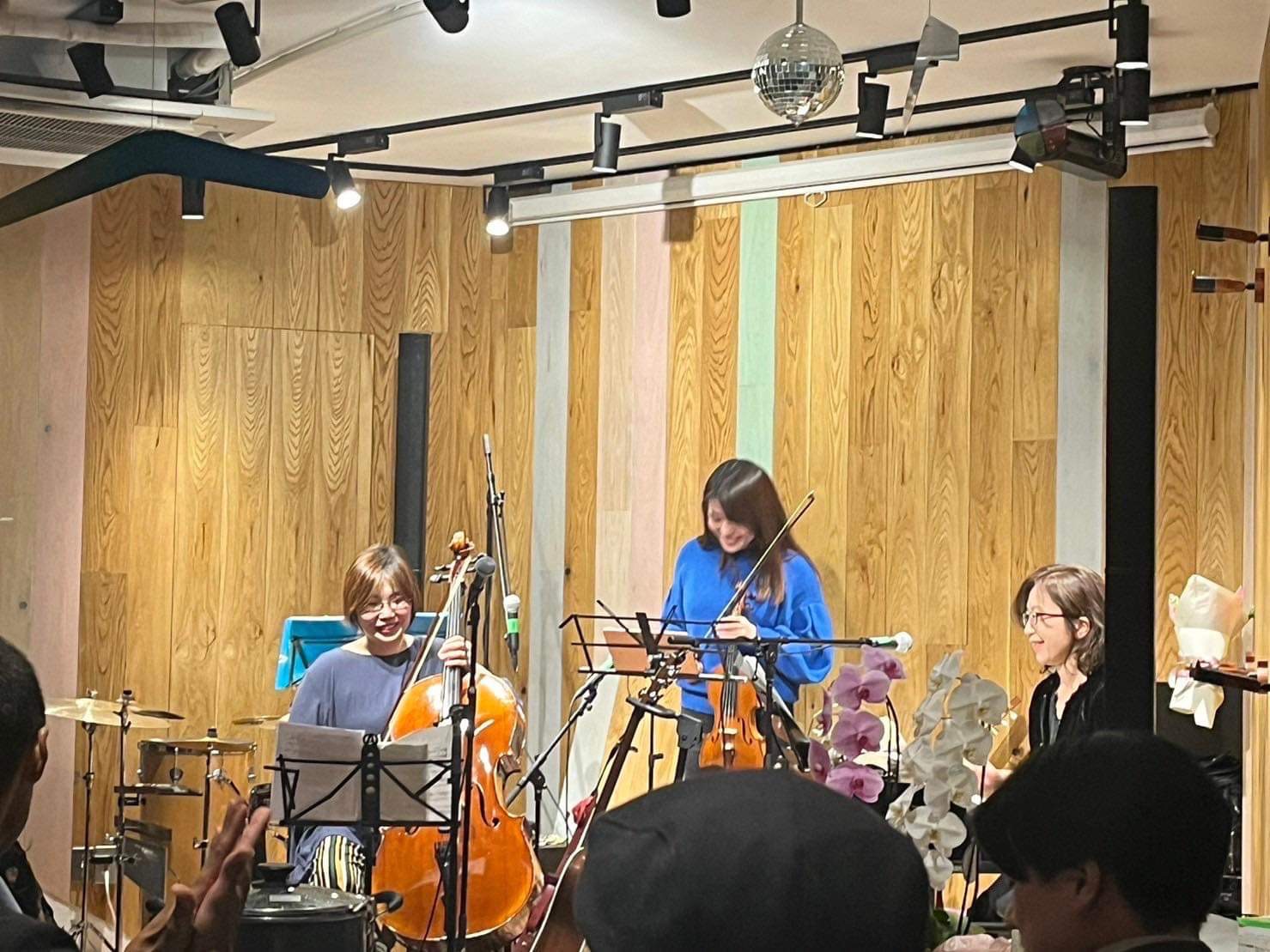会場で笑顔で演奏するデュオと拍手する客席
